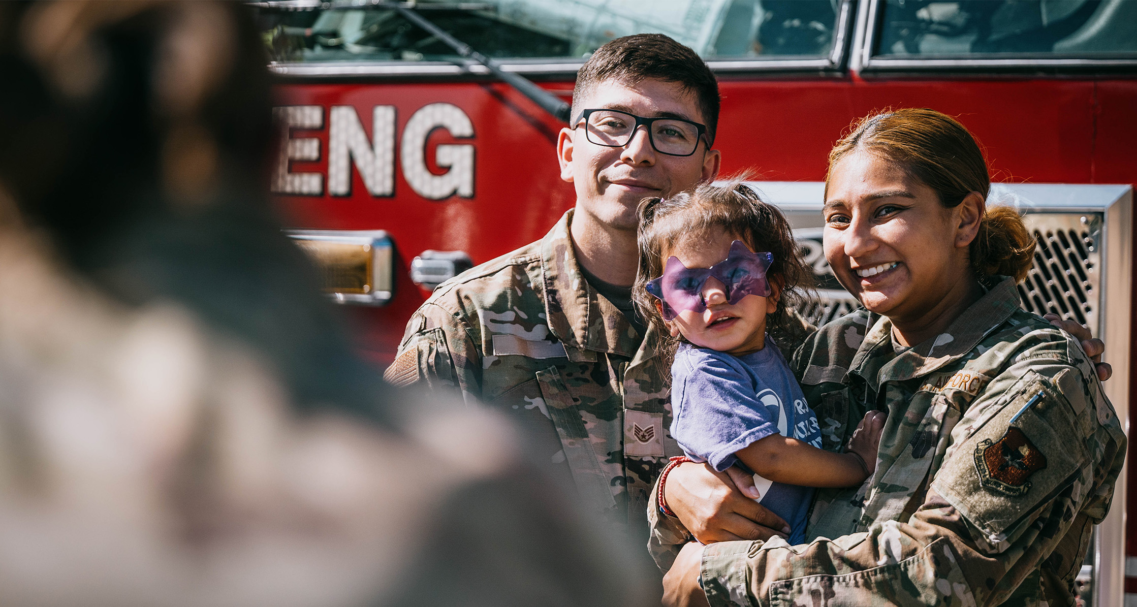 U.S. Air Force Airmen take a photo with their child following the Purple Up parade.