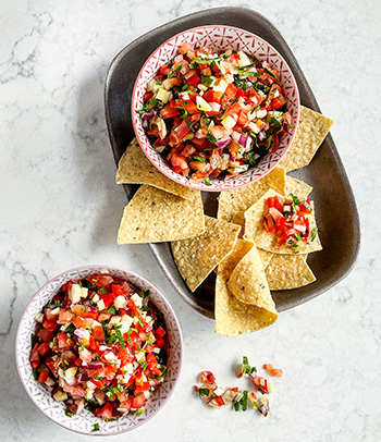 Bowls of Pico de Gallo with corn tortilla chips.