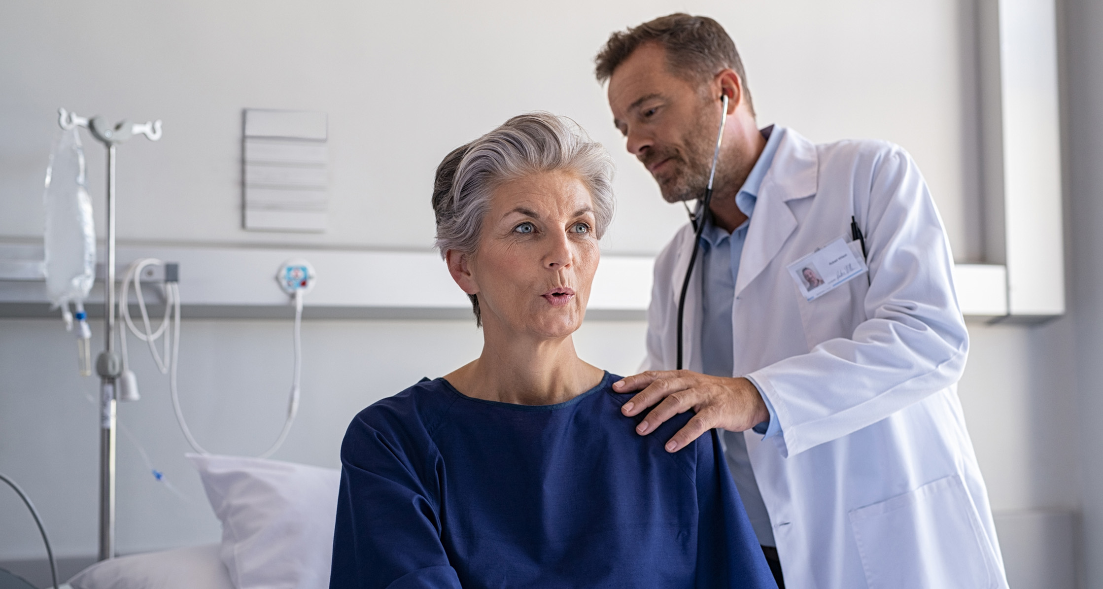 Physician checking a woman’s lung sounds through a stethoscope.