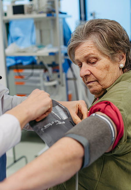 Senior woman having blood pressure checked in hospital.