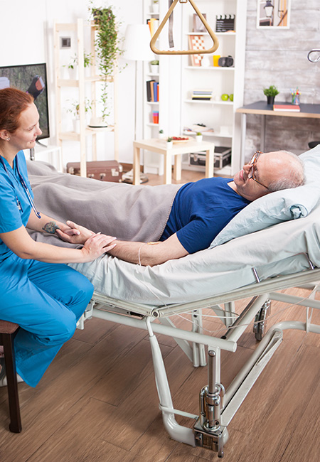 Hospice caregiver holding patient’s hand.