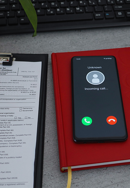 Unknown caller on phone depicting tax scam solicitation.