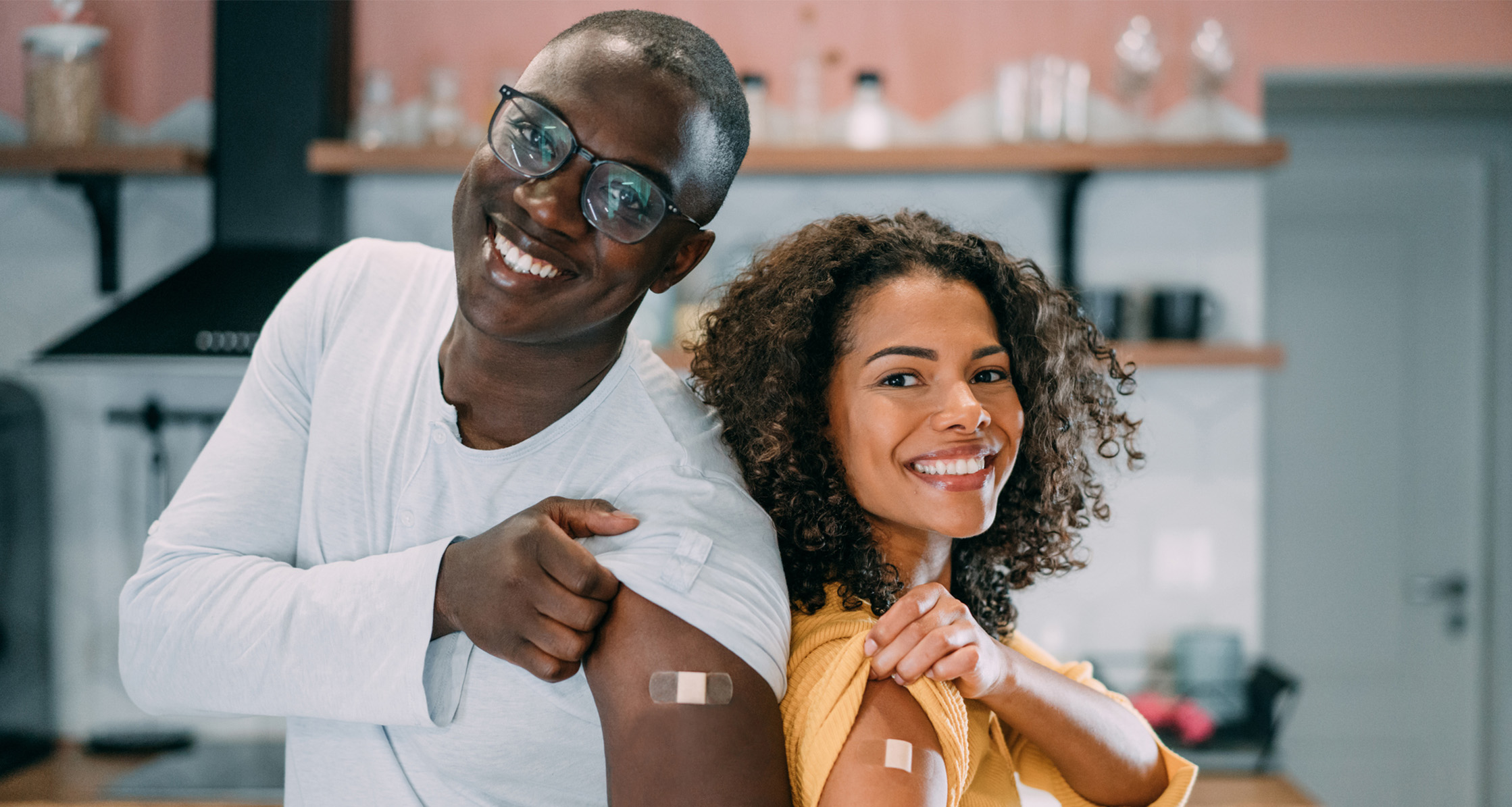 A young military couple proudly displaying their arms after receiving their vaccinations.