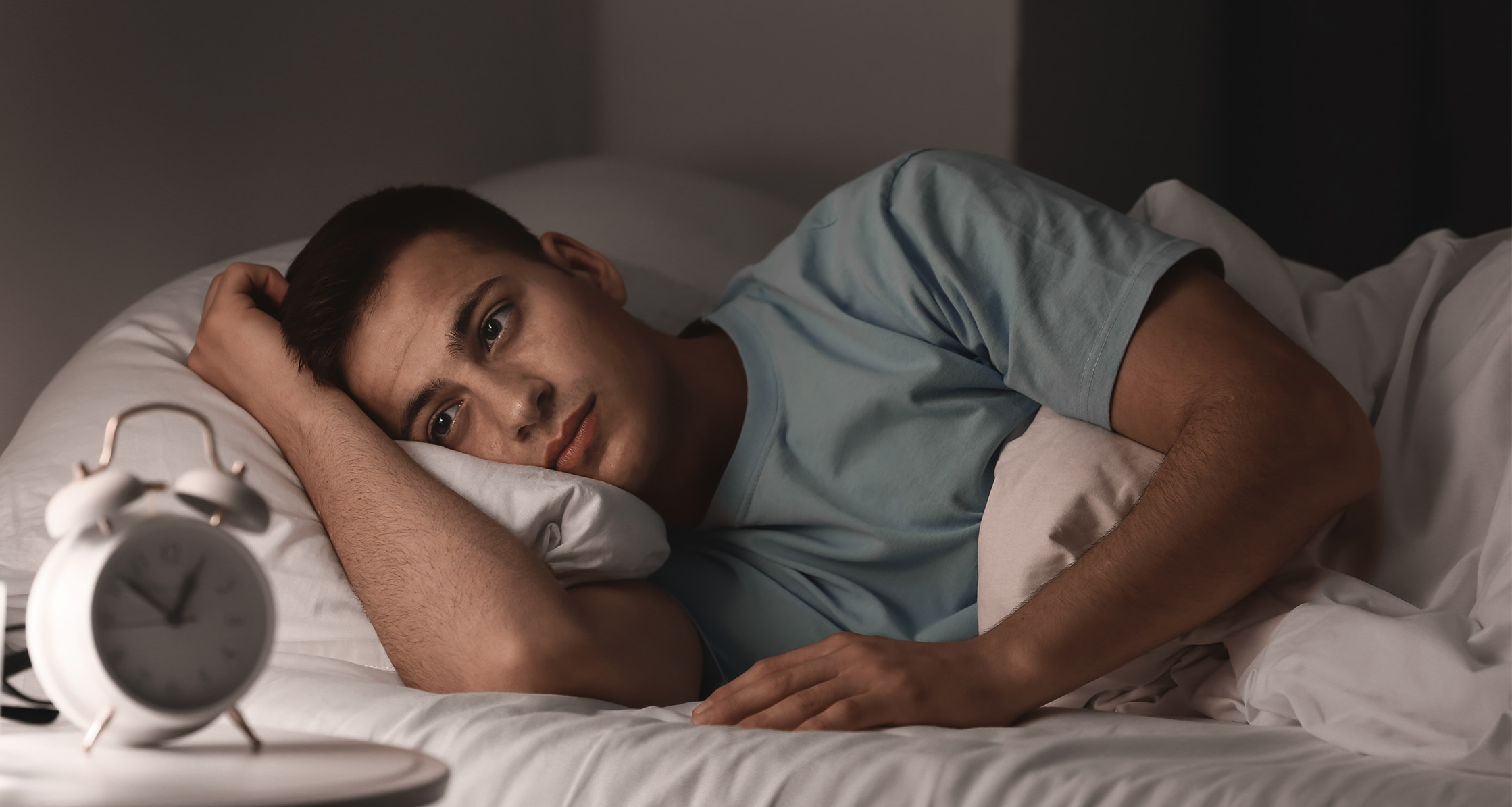 A man with insomnia lies in bed.