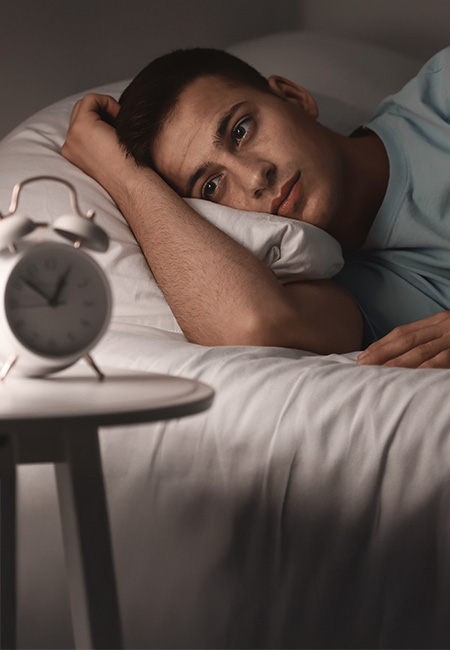 A man with insomnia lies in bed.