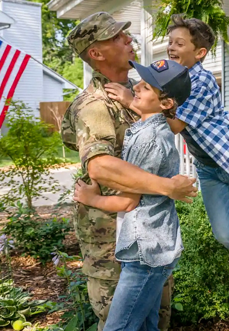 Military family outside their new home.