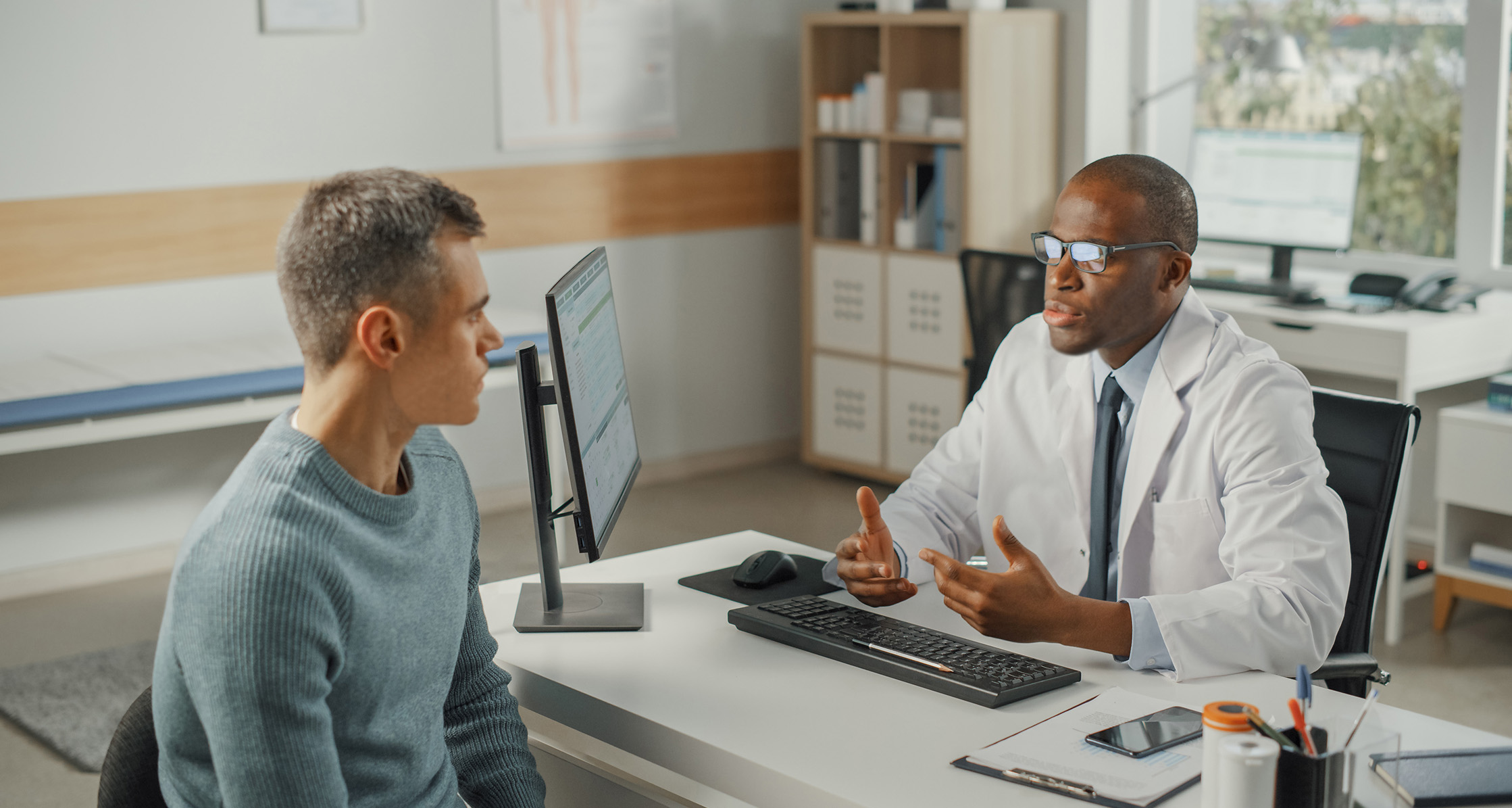 Veteran discussing health concerns with a medical provider during an office visit.
