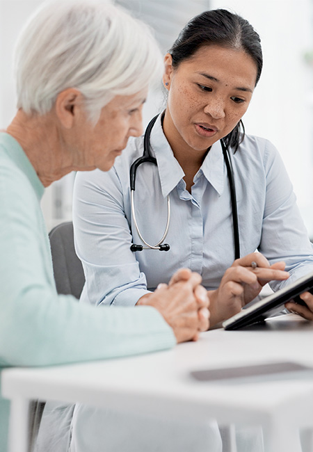 Veteran sitting with health care provider reviewing medical benefits.