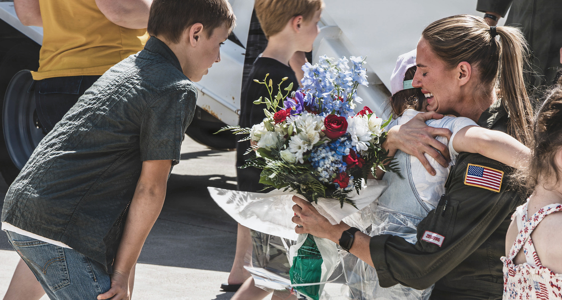 Service member reunited with children after deployment.