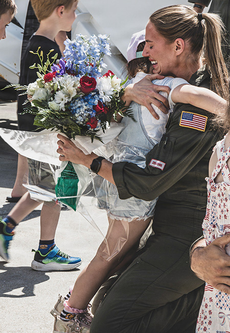 Service member reunited with children after deployment.
