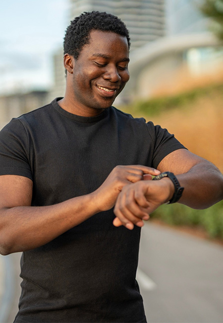 Person looking at activity tracker while walking.