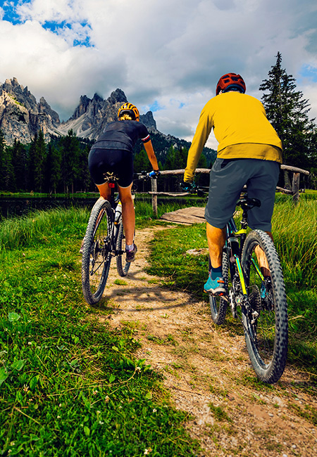 A couple biking on a mountain trail.